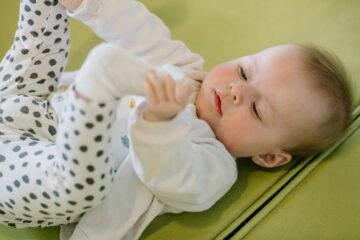 Baby speelt met voetjes op kinderopvang