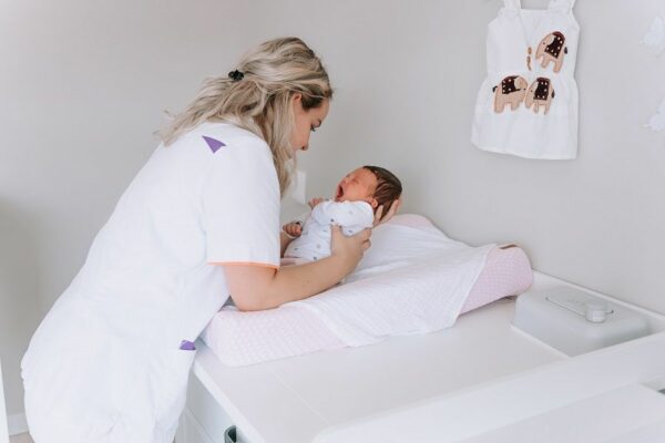 Naviva kraamzorg legt baby op verschoningskussen