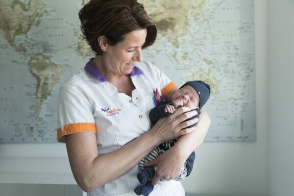 Kraamzorg houdt baby vast op haar arm