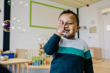 Jongetje speelt op de kinderopvang nadat de kosten kinderopvang zijn voldaan