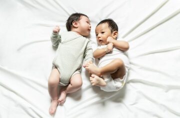 Pasgeboren Aziatische tweeling ligt op bed