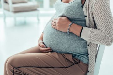 Zwangere vrouw heeft net haar slijmprop verliezen en rust uit op stoel