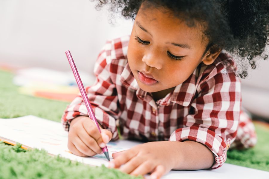 Jong meisje kleurt bij het kinderdagverblijf