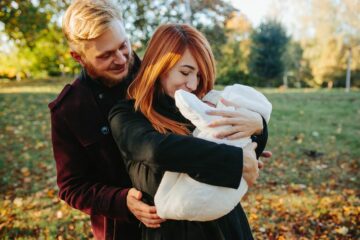 Jonge ouders met pasgeboren baby in de herfst