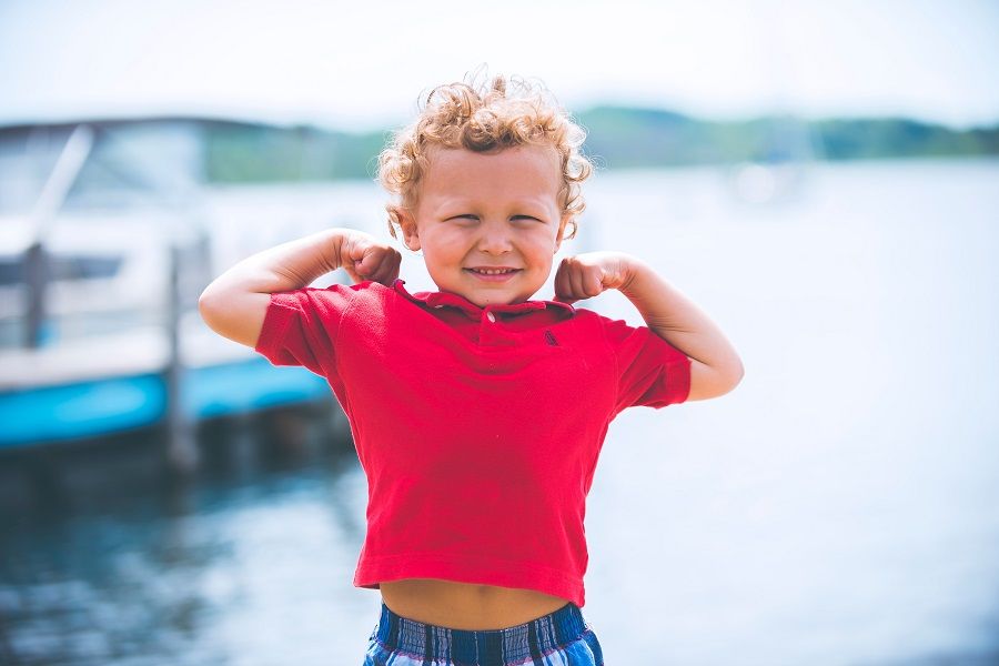 Kleine jongen toont spierballen