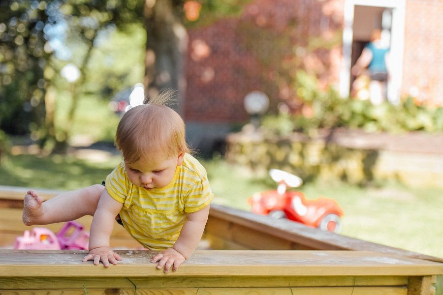 Kind speelt in zandbak bij kinderdagverblijf