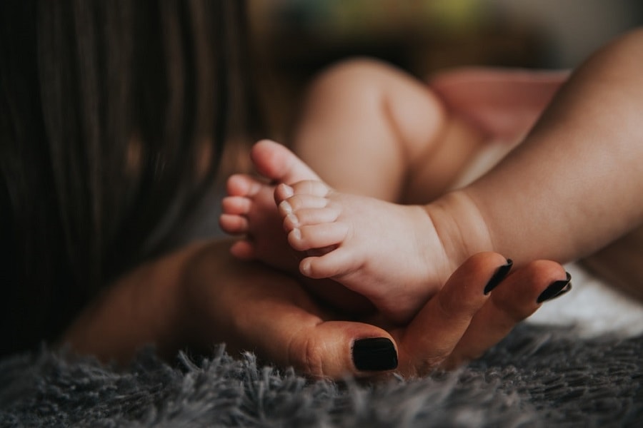 Onzekere moeder houd babyvoetjes vast