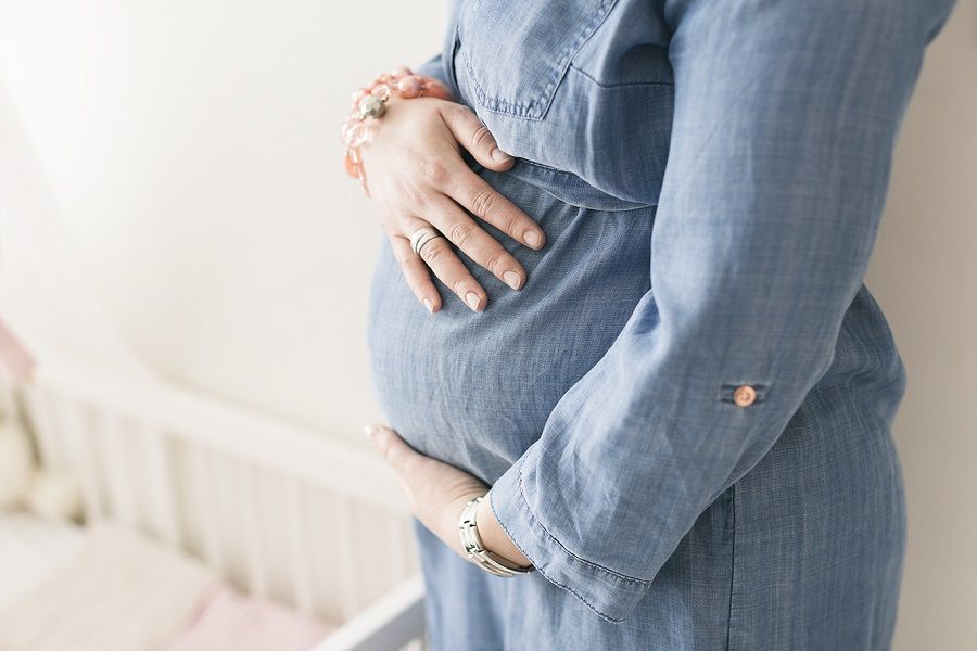 Vrouw houdt zwangere buik vast