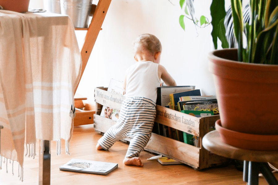 Baby staat onstabiel bij stapel tijdschriften
