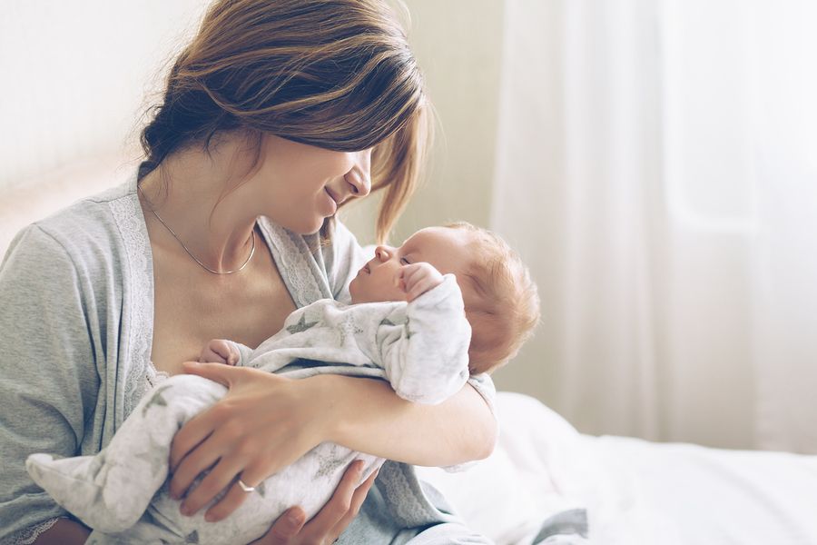Moeder knuffelt pasgeboren baby en geniet van startgeld uit het Groeipakket