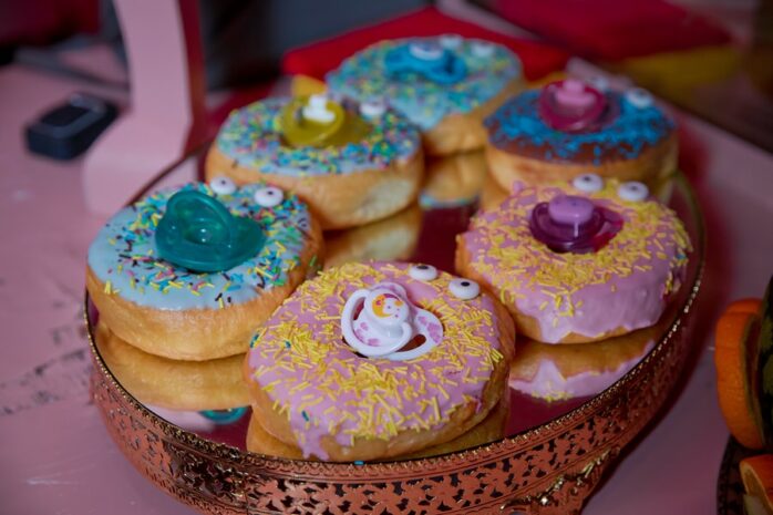 Blauwe en roze gekleurde donuts met speen als babyshowerhapje