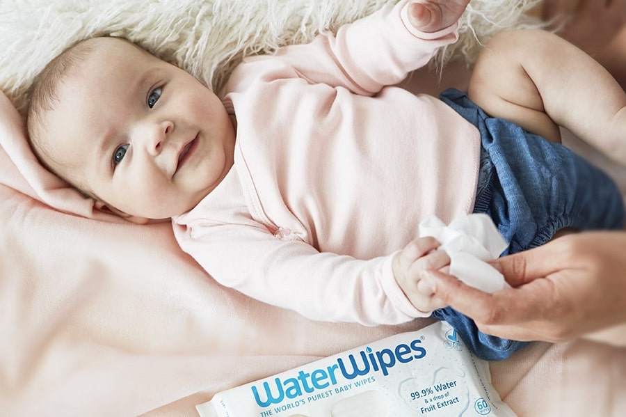 Meisje speelt met WaterWipes doekjes op bed