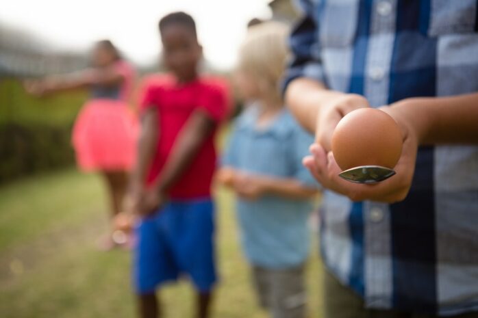 Kinderen spelen een eierrace terwijl ze paasspelletjes spelen