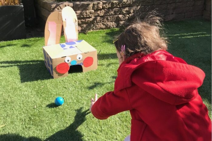 Meisje speelt paasgolf tijdens paasspelletjes spelen