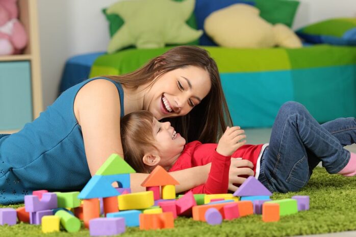 Moeder en dochter lachen om leuke raadsels en kindermoppen
