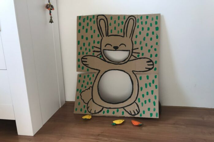 Paasspelletje waarbij je een kartonnen haasje voert door stoffen wortels in zijn mond en buik te gooien