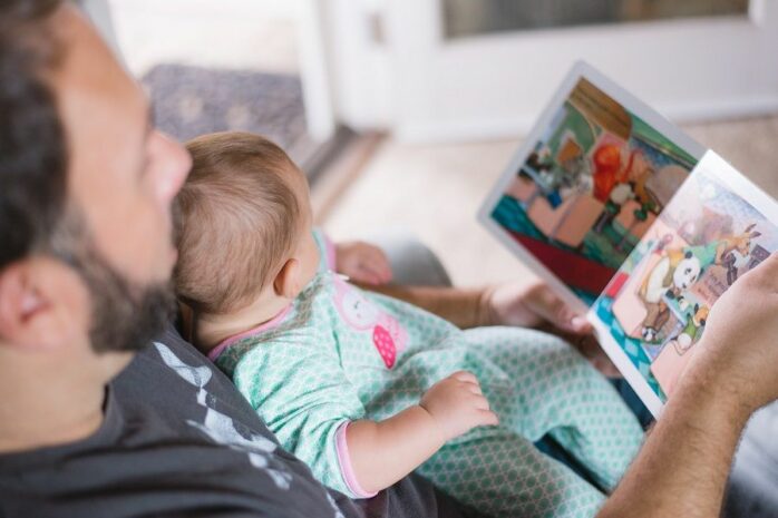 Vader leest boekje met kind voor taalontwikkeling