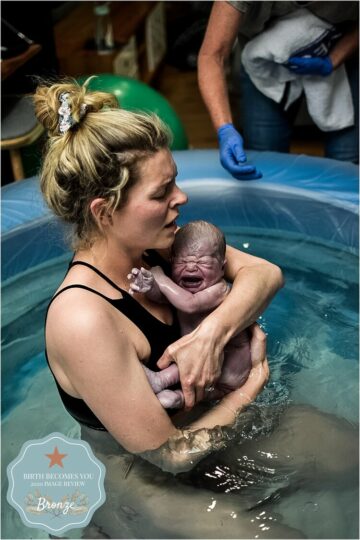 Moeder houdt haar pasgeboren baby vast in bad