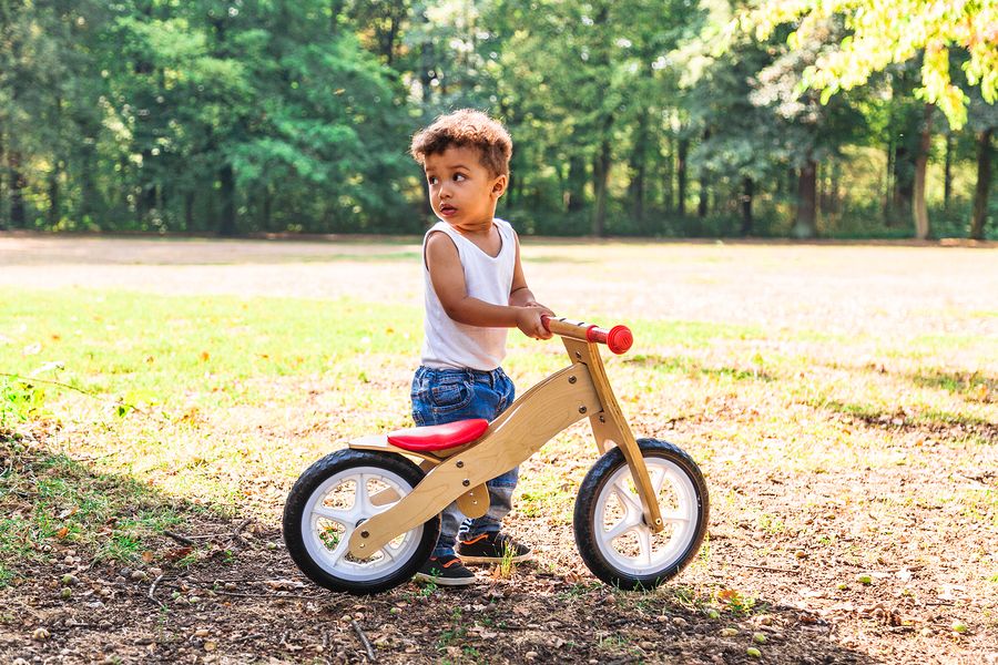 Jongen met loopfiets in bos
