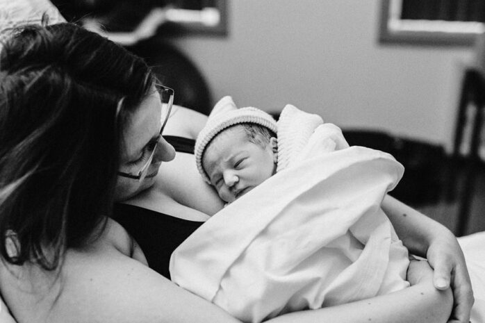 Moeder kijkt trots naar haar pasgeboren baby