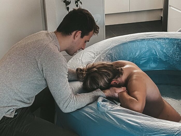 Ilona vangt haar weeën op in bad terwijl haar partner haar vasthoudt