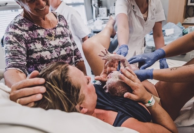 Baby wordt op borst van pas bevallen vrouw gelegd