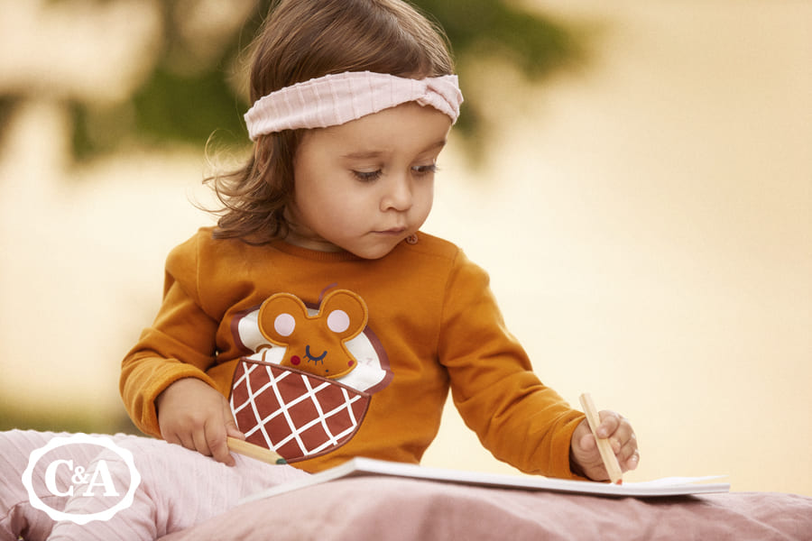 meisje draagt babykleding van C&A
