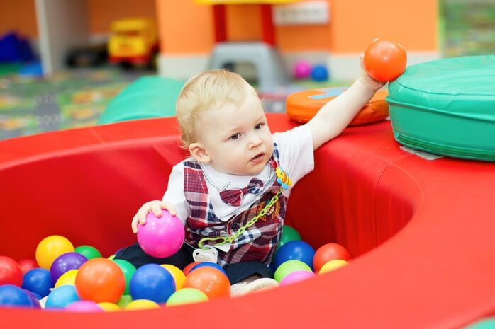 Dreumes zit in ballenbak in indoor speeltuin