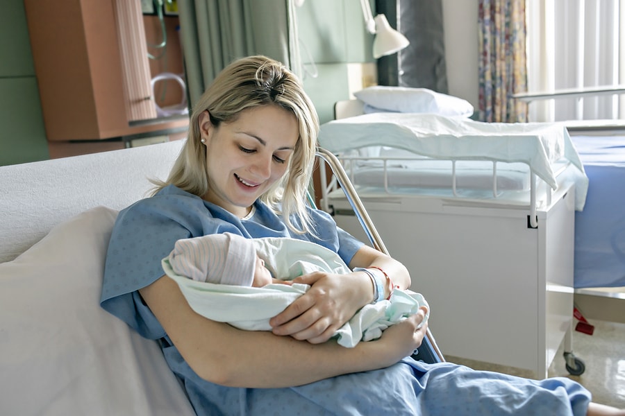 Moeder met pasgeboren baby en na de nageboorte van de placenta