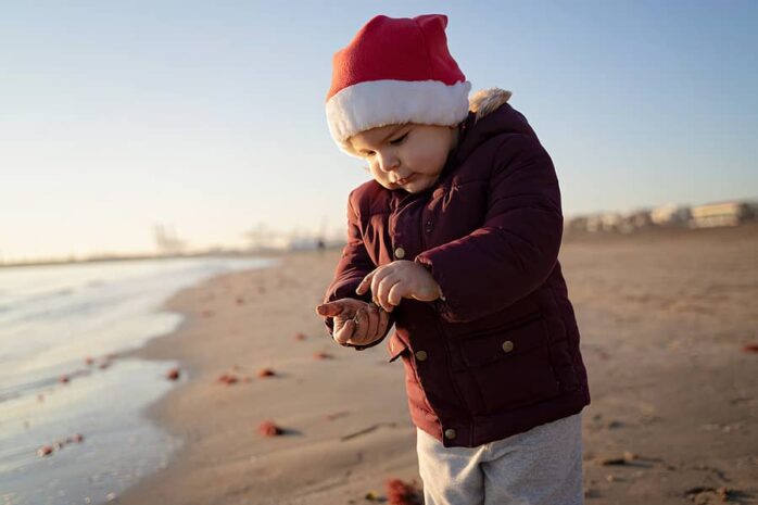 Peuter viert kerstvakantie op het strand