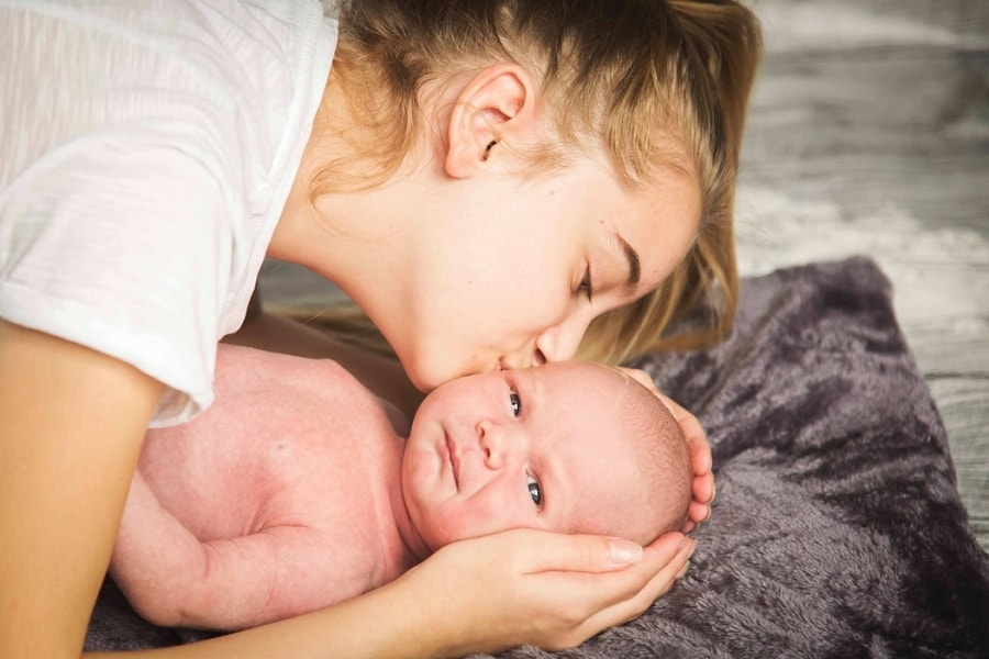 Onzekere kersverse mama kust haar pasgeboren baby