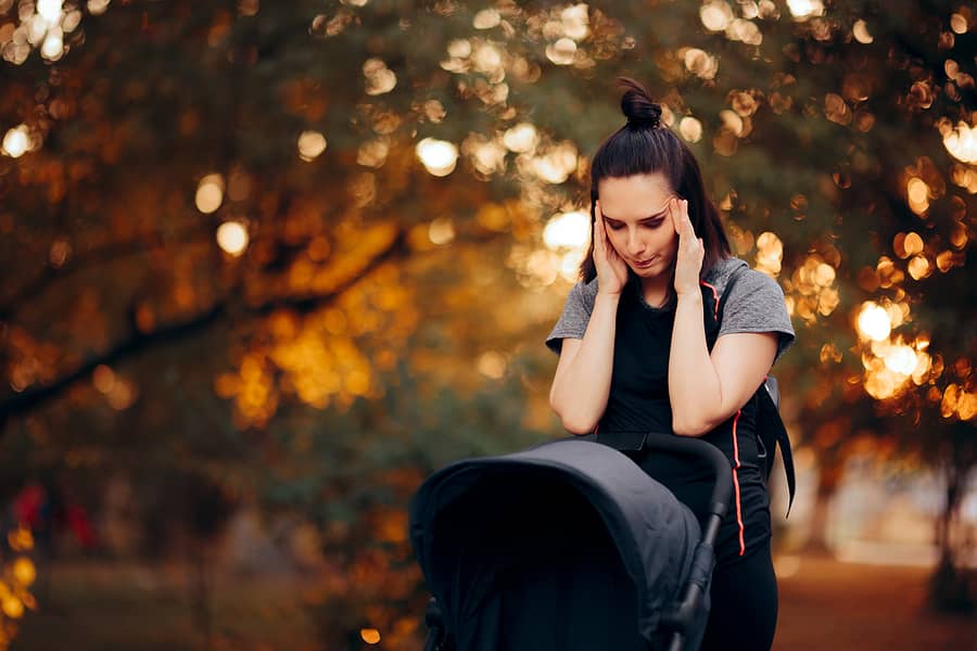 Moeder wandelt buiten met haar baby en worstelt met kraambedspychose