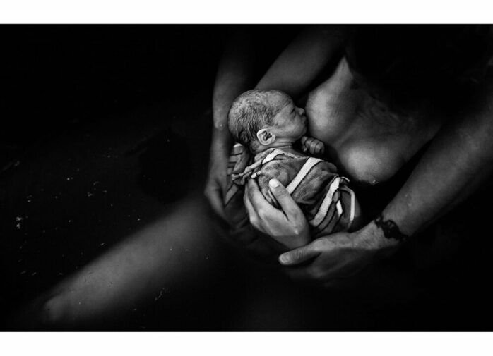 Pasgeboren baby aan de borst van moeder