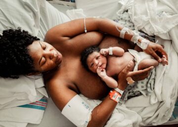 Pageboren baby ligt op buik van moeder