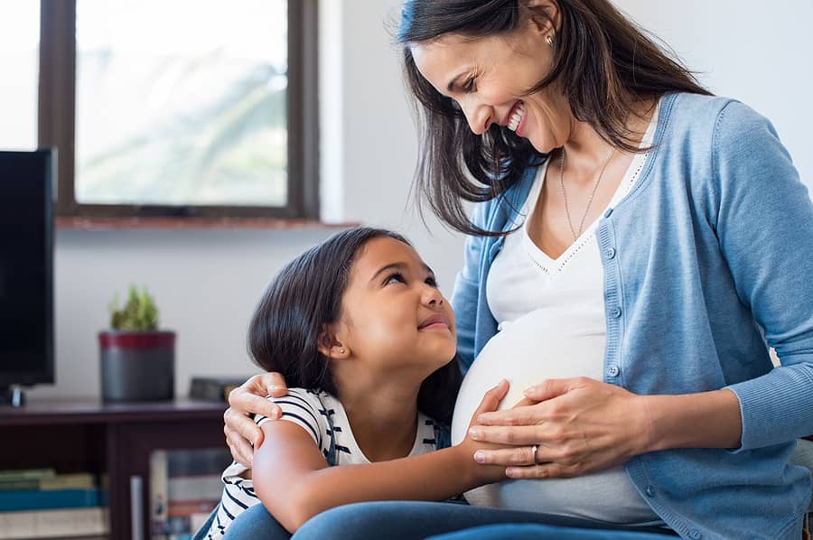 Dochter aait moeders baby bump