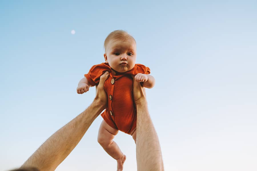 Vader houdt baby vast met stoere meisjesnamen