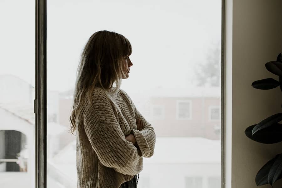 Vrouw staart bezorgd uit raam