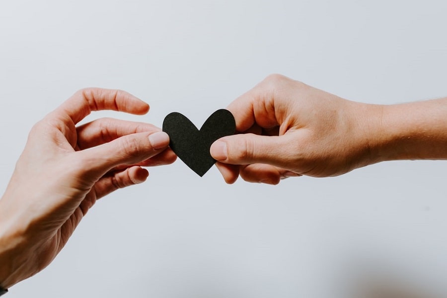 Twee vrouwen houden een hartje vast om elkaar te ondersteunen
