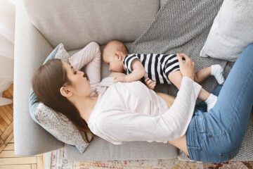 Moeder voedt haar baby in een van meest ontspannen borstvoedingshoudingen: in zijligging