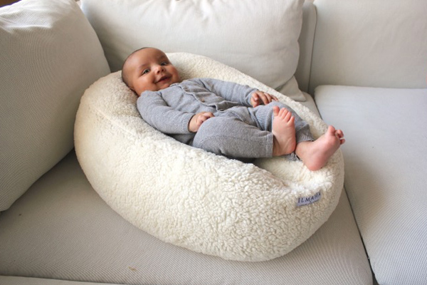 Baby ligt in voedingskussen met relaxhoes van Ilmaha