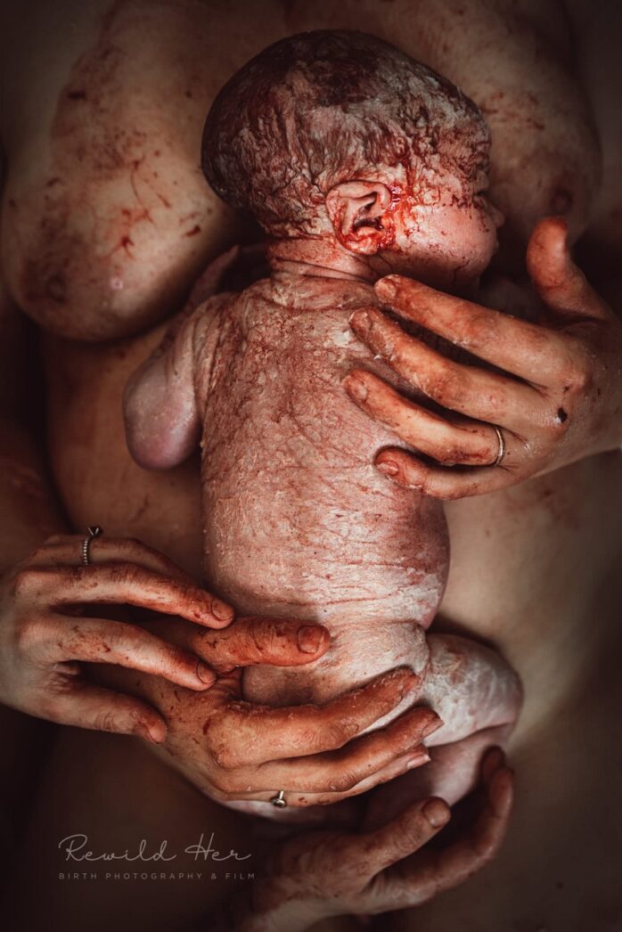 Pasgeboren baby in armen van moeder