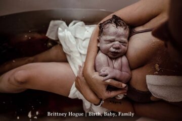 Pasgeboren baby in armen van moeder