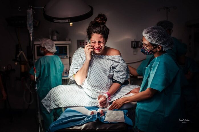 Vrouw is huilend aan het bellen tijdens bevalling