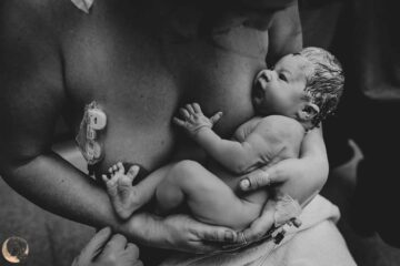 Pasgeboren baby in armen van moeder