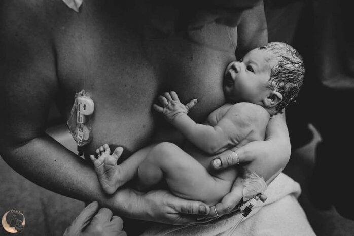 Pasgeboren baby in armen van moeder