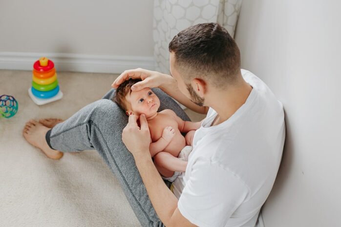 Vader speelt babyspelletjes met zijn baby van 1 maand oud