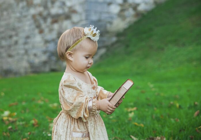 Meisje met sprookjesachtige babynaam met kroontje en boek