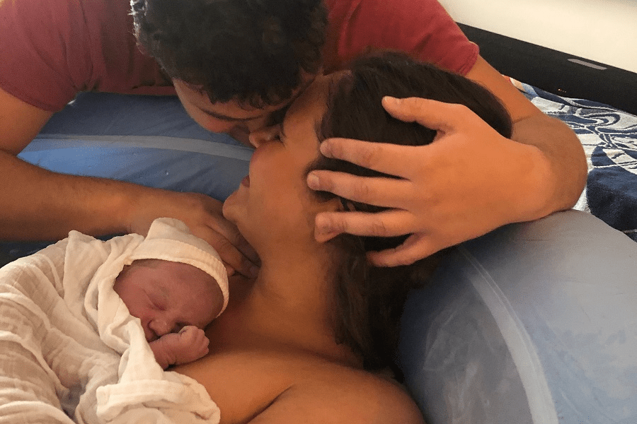 Faye samen met haar partner en baby vlak na haar bevalling in een bevalbad