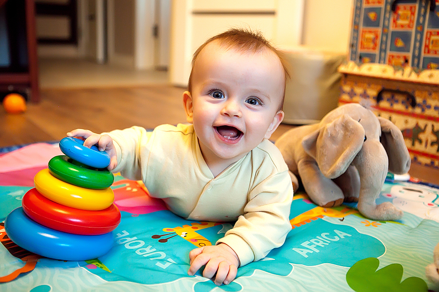 Baby 21 Wochen spielt auf Spieldecke