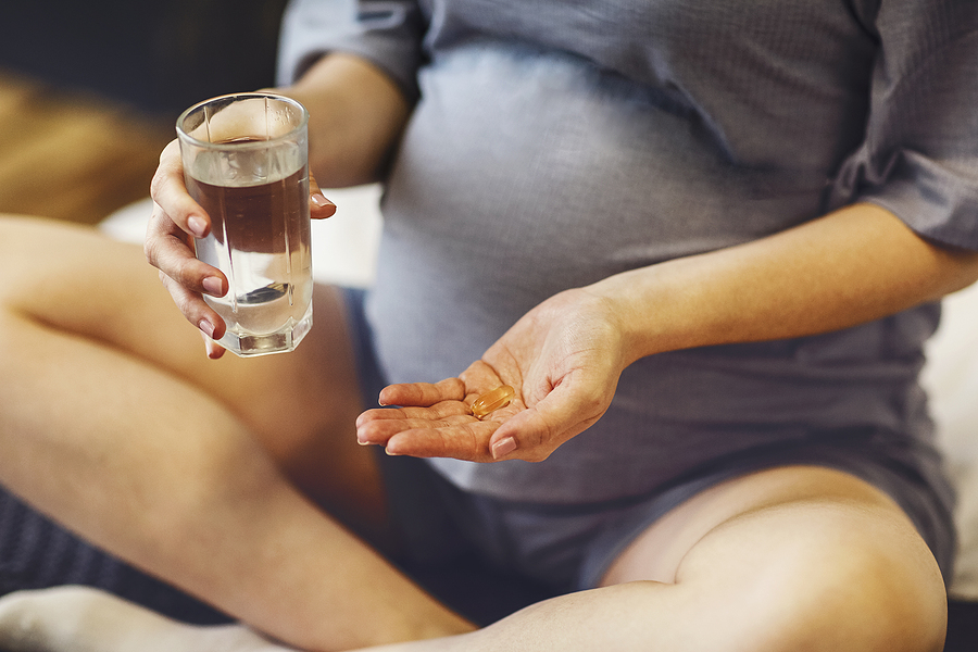 Eine Schwangere nimmt ihre Schwangerschaftsvitamine.